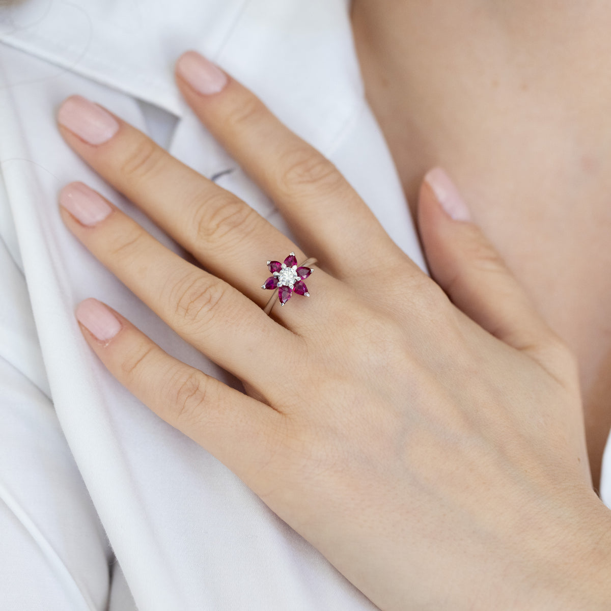18kt white gold ring with ruby flower petals and 0.42 carat central diamond