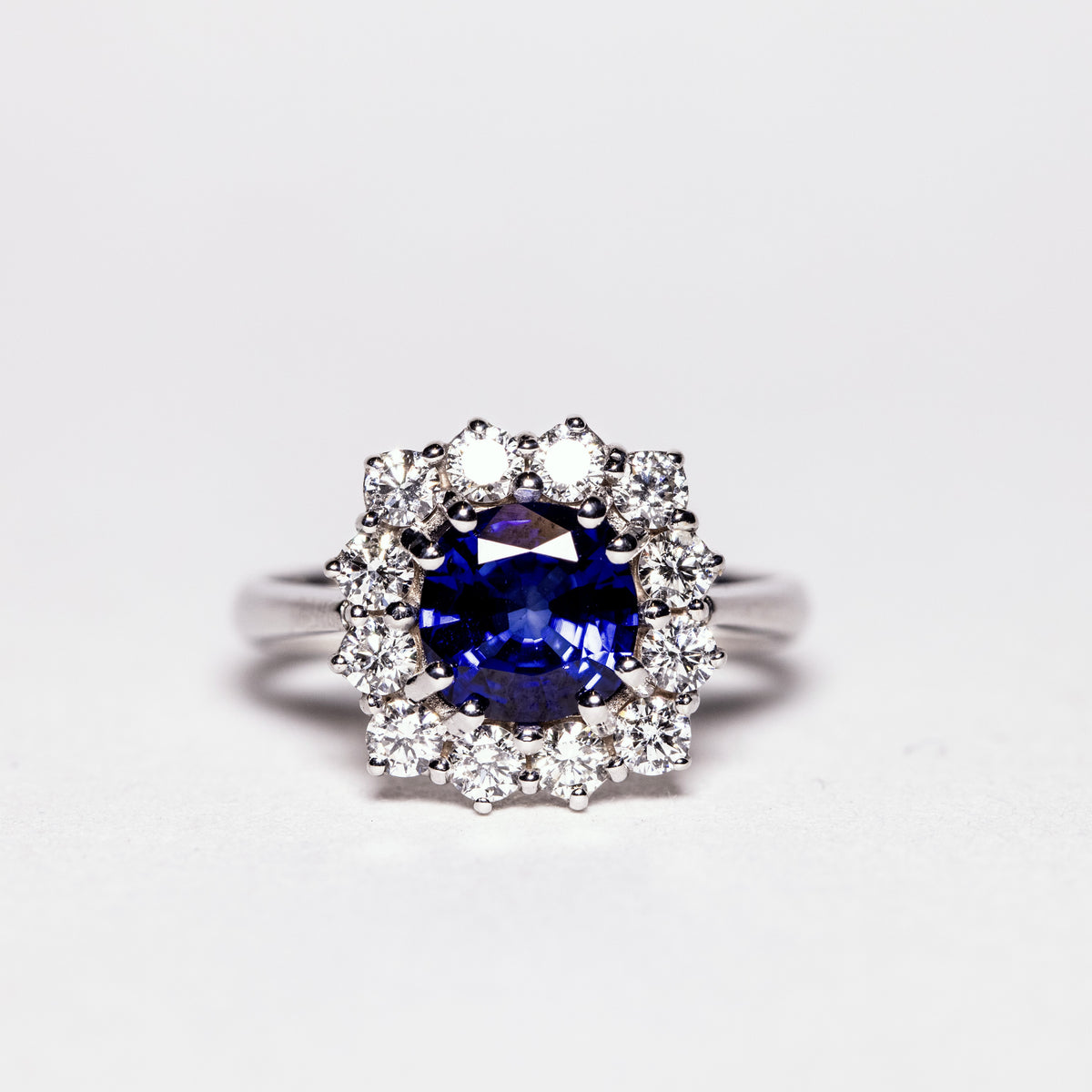 18KT White Gold Ring with Circular Sapphire and Diamond Surround
