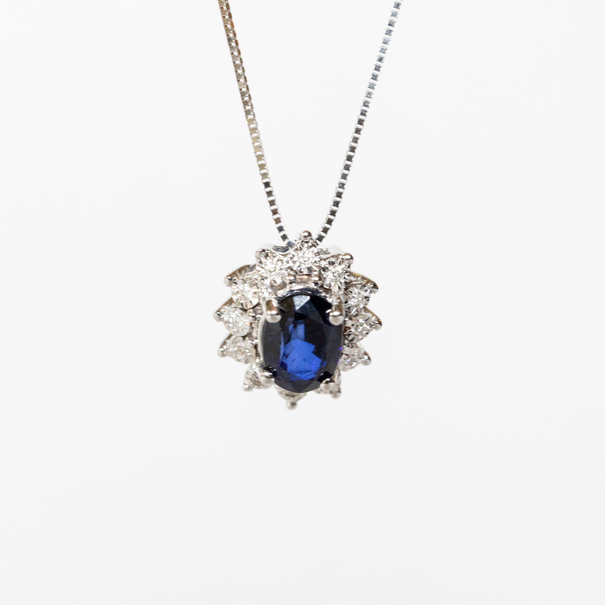18kt white gold necklace with central sapphire and diamond surround