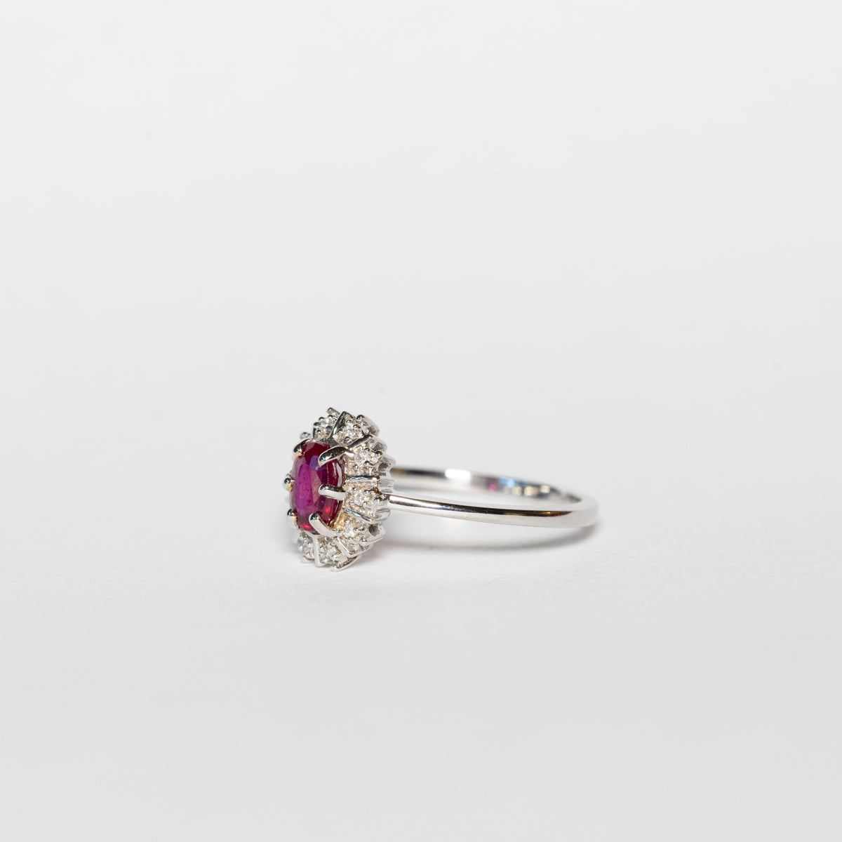 Anello in oro bianco 18 kt con rubino ovale e giro di diamanti