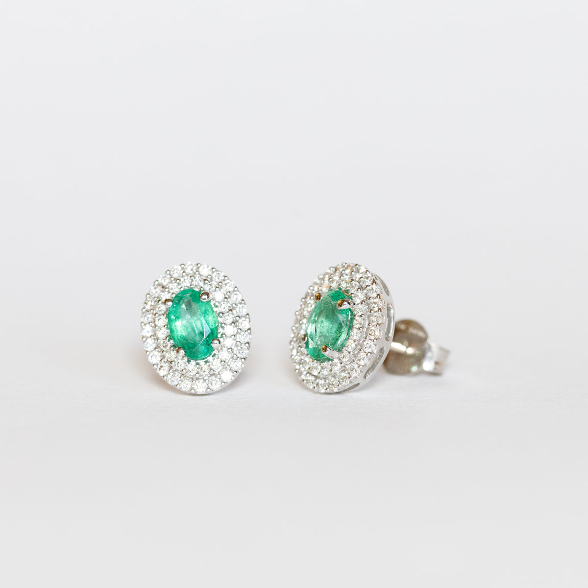 Orecchini in oro bianco 18 kt con smeraldi e doppio giro di diamanti