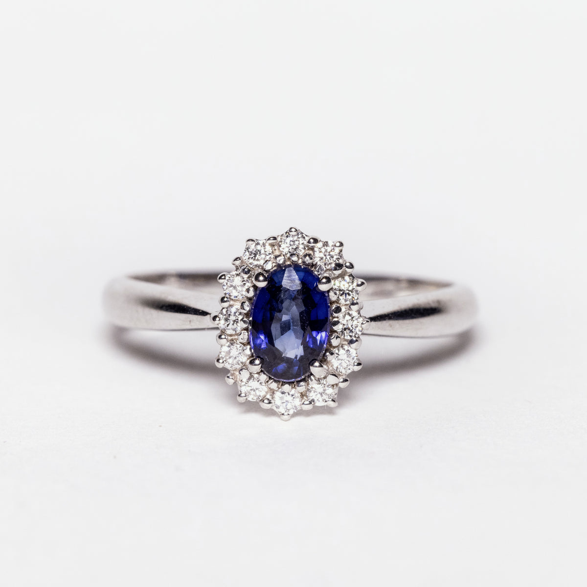 18kt white gold ring with sapphire surrounded by diamonds