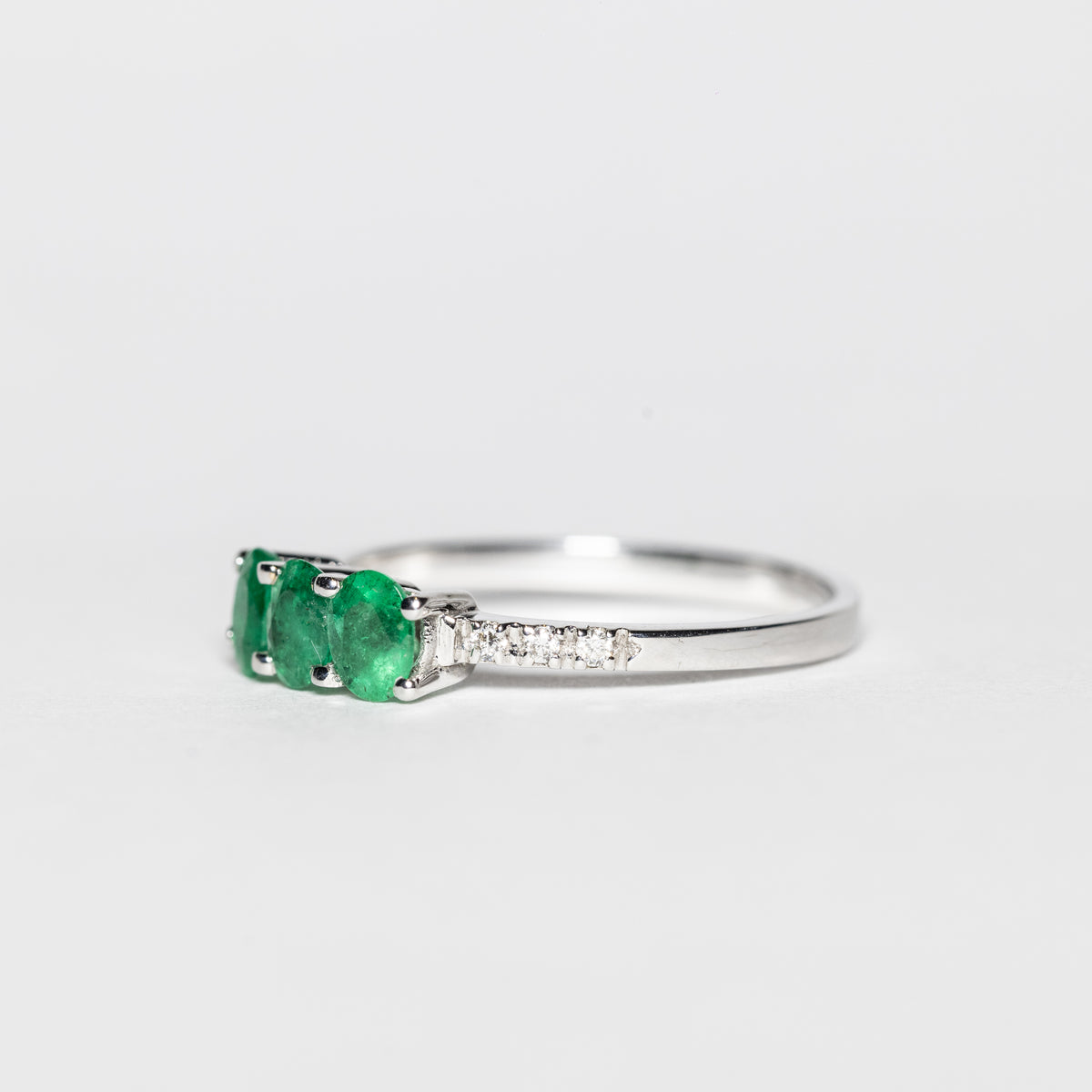 18KT White Gold Trilogy Ring with Emeralds and Diamonds on the Setting