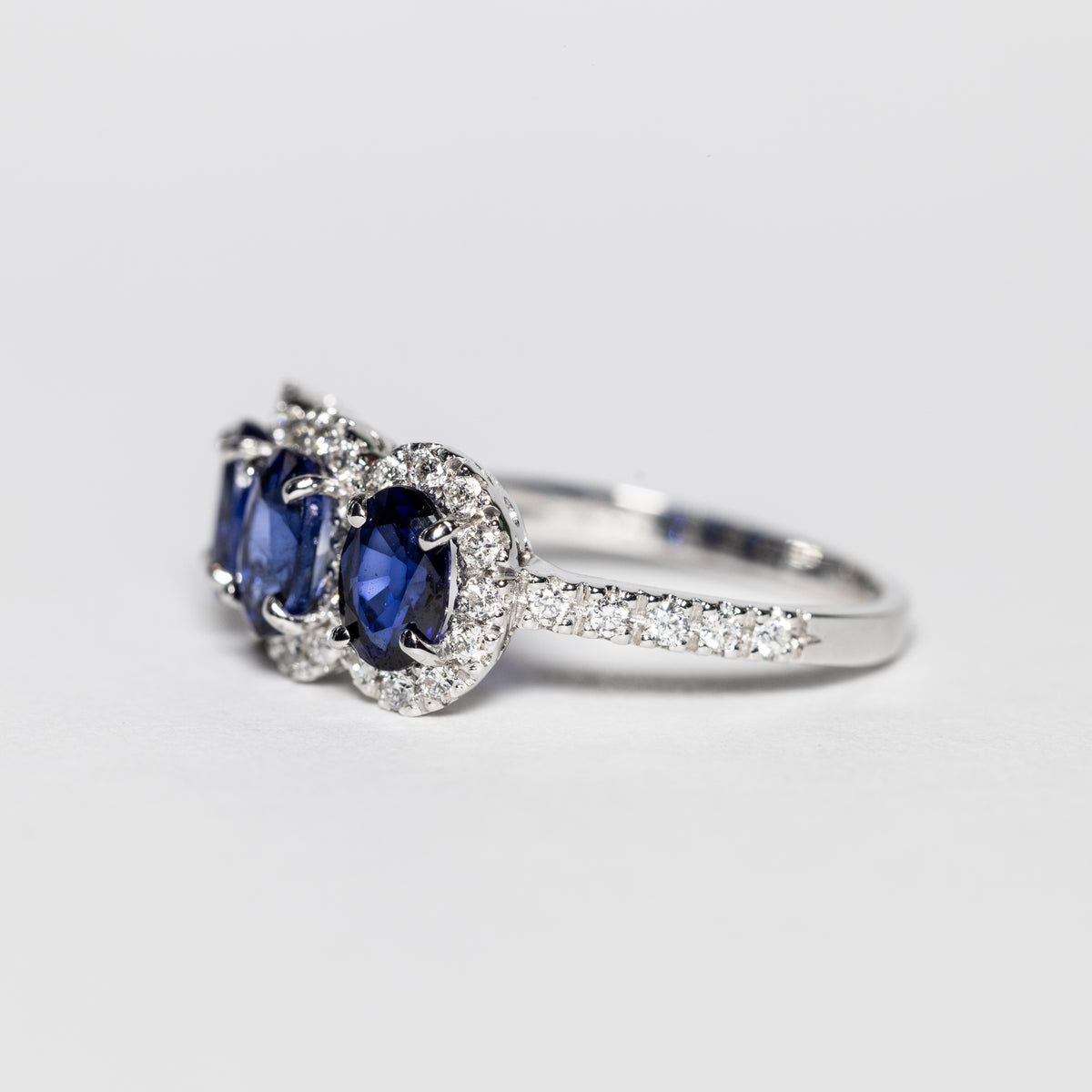 Anello Trilogy in Oro Bianco 18 KT con Zaffiri e Giro di Diamanti