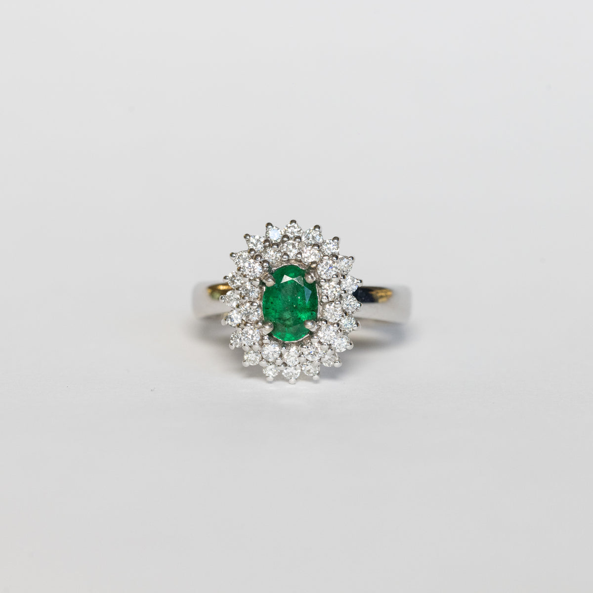 Anello in Oro Bianco 18 kt con Smeraldo Centrale e Doppio giro di Diamanti