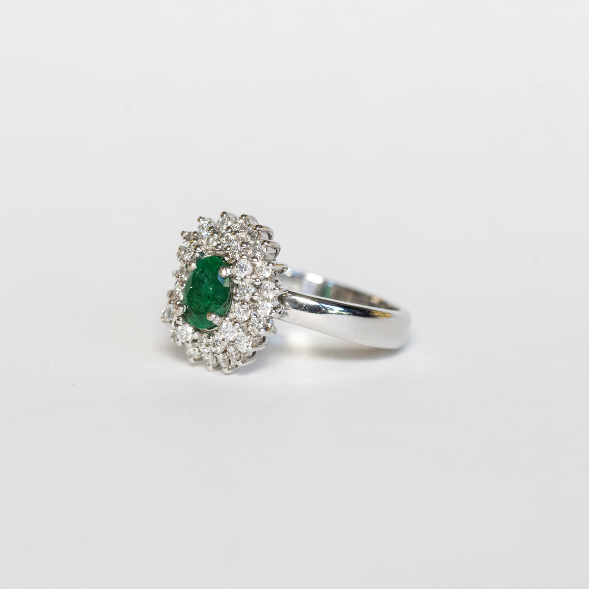 Anello in Oro Bianco 18 kt con Smeraldo Centrale e Doppio giro di Diamanti