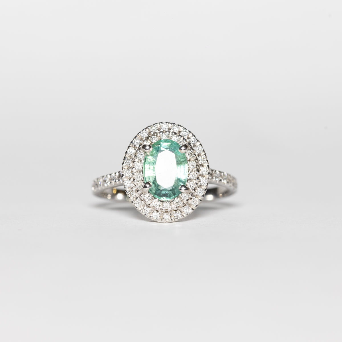 Anello in Oro Bianco 18 KT con Smeraldo Centrale e Doppio Giro di Diamanti