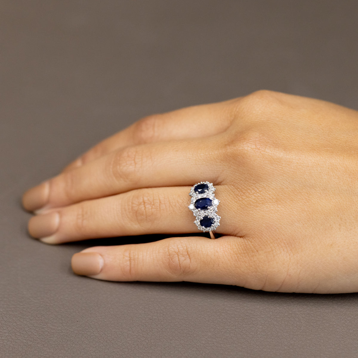 18Kt White Gold Trilogy Ring with Sapphires Surrounded by Diamonds