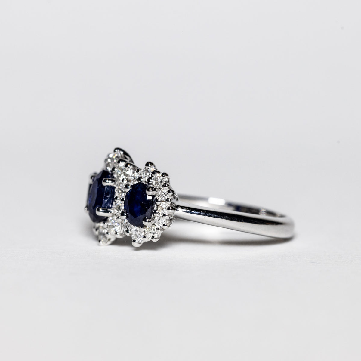 18Kt White Gold Trilogy Ring with Sapphires Surrounded by Diamonds