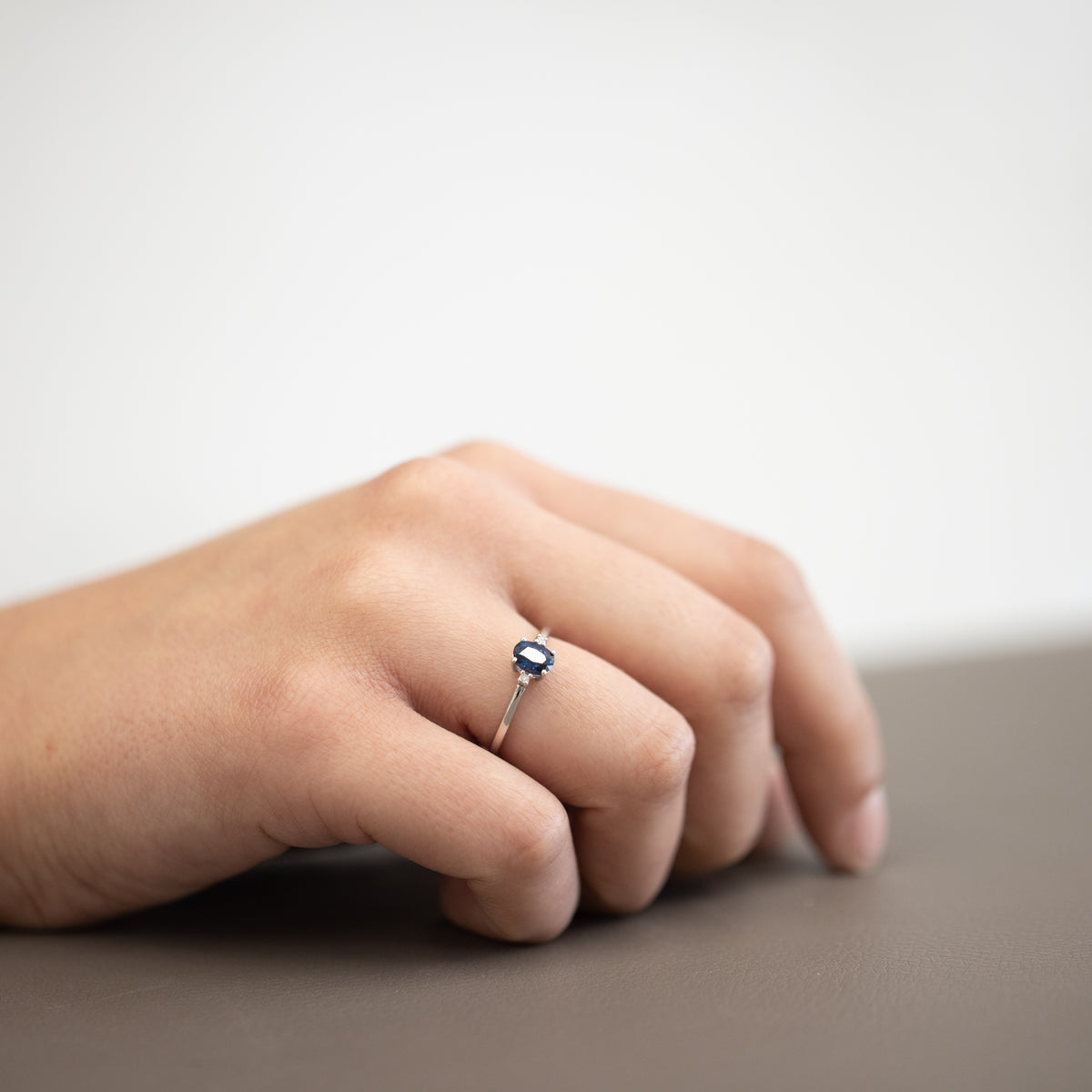 Anello in oro bianco 18kt con zaffiro ovale centrale e diamanti laterali