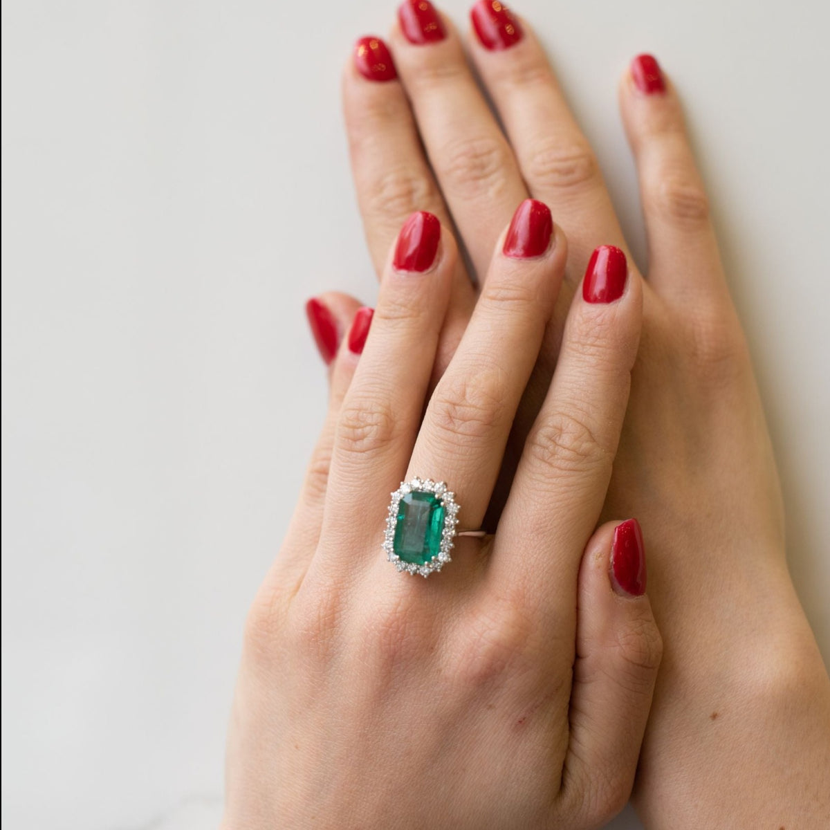 Anello Solitario in Oro Bianco 18KT con Smeraldo da 7 Carati e contorno in Diamanti (Pezzo Unico)