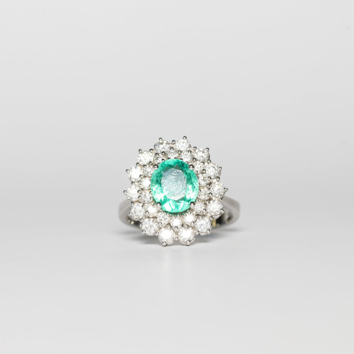 18KT White Gold Ring with Oval-Shaped Central Emerald and Double Diamond Surround
