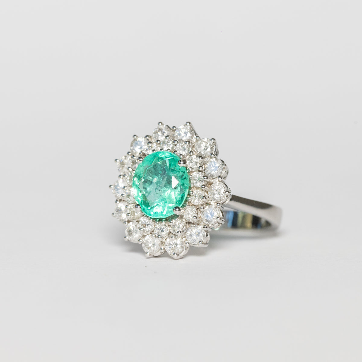 18KT White Gold Ring with Oval-Shaped Central Emerald and Double Diamond Surround