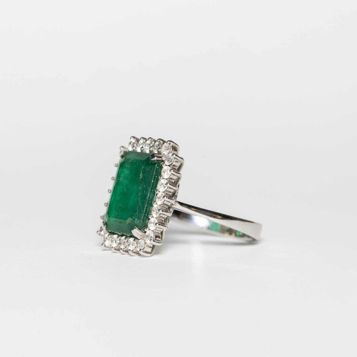 Anello in oro bianco 18 kt con smeraldo  taglio emerald centrale e contorno di diamanti