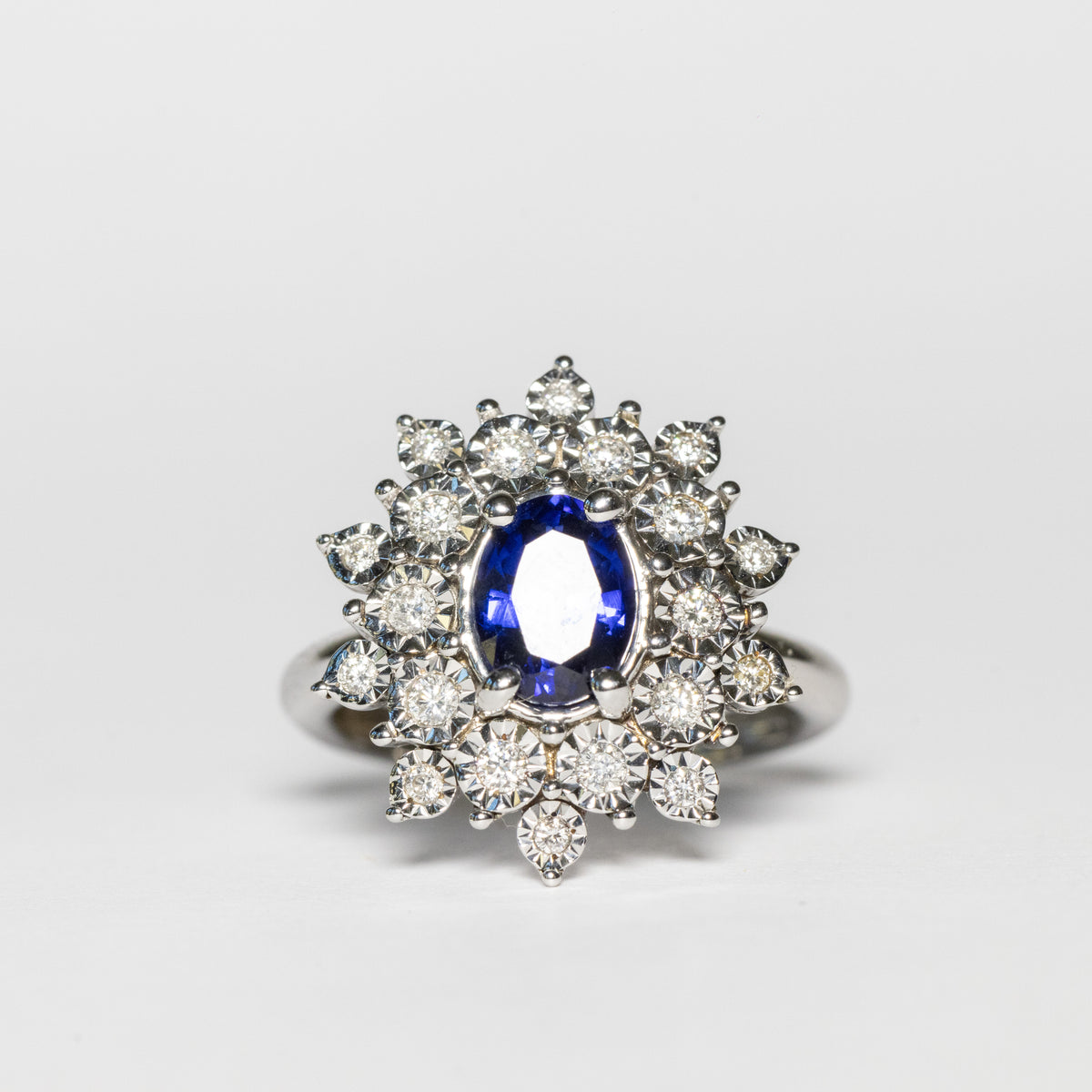 18kt white gold ring with central oval sapphire and double row of diamonds