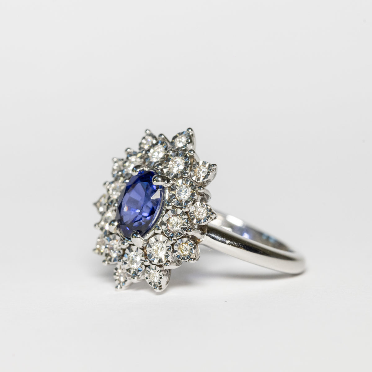 18kt white gold ring with central oval sapphire and double row of diamonds