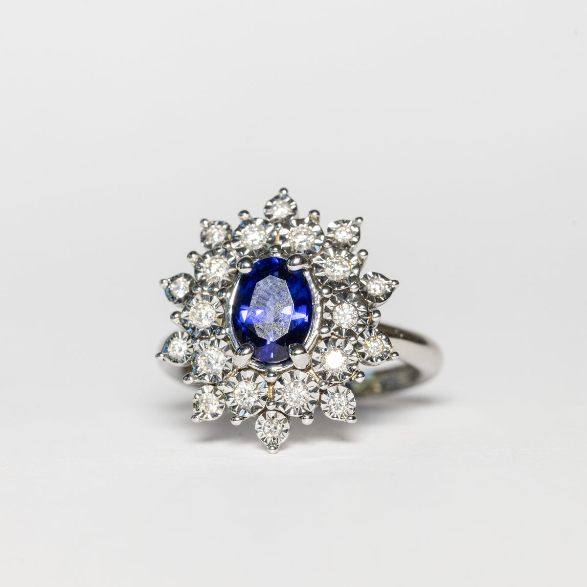18kt white gold ring with central oval sapphire and double row of diamonds