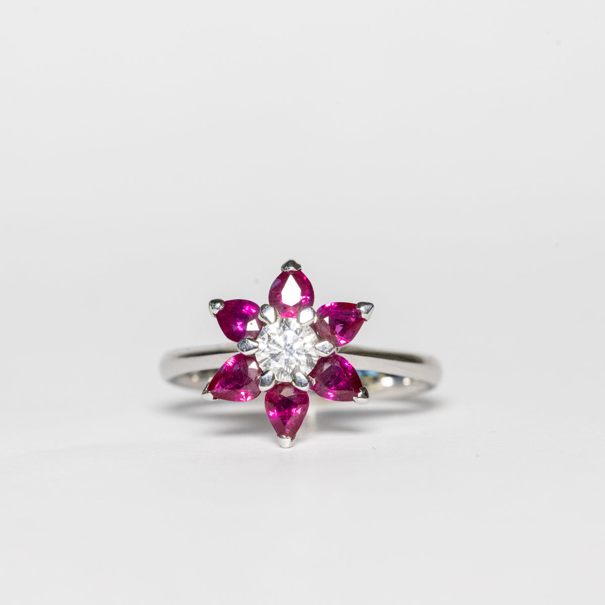 Anello in oro bianco 18kt  con petali fiore in rubino e diamante centrale da 0,42 Carati