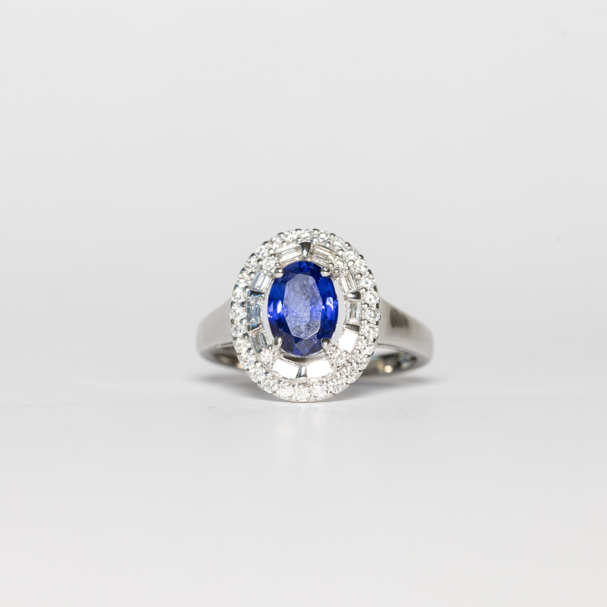 18kt white gold ring with central sapphire and surrounded by illusion diamonds