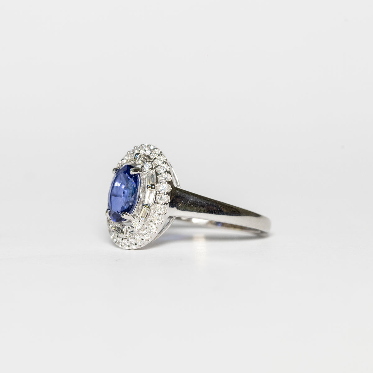 18kt white gold ring with central sapphire and surrounded by illusion diamonds