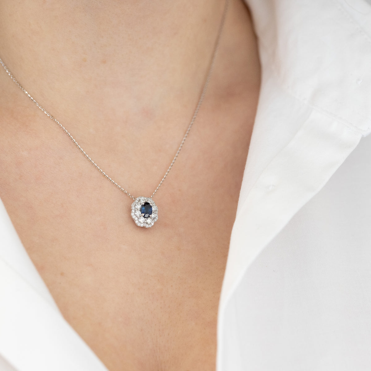 18kt white gold necklace with oval sapphire and double diamond contour