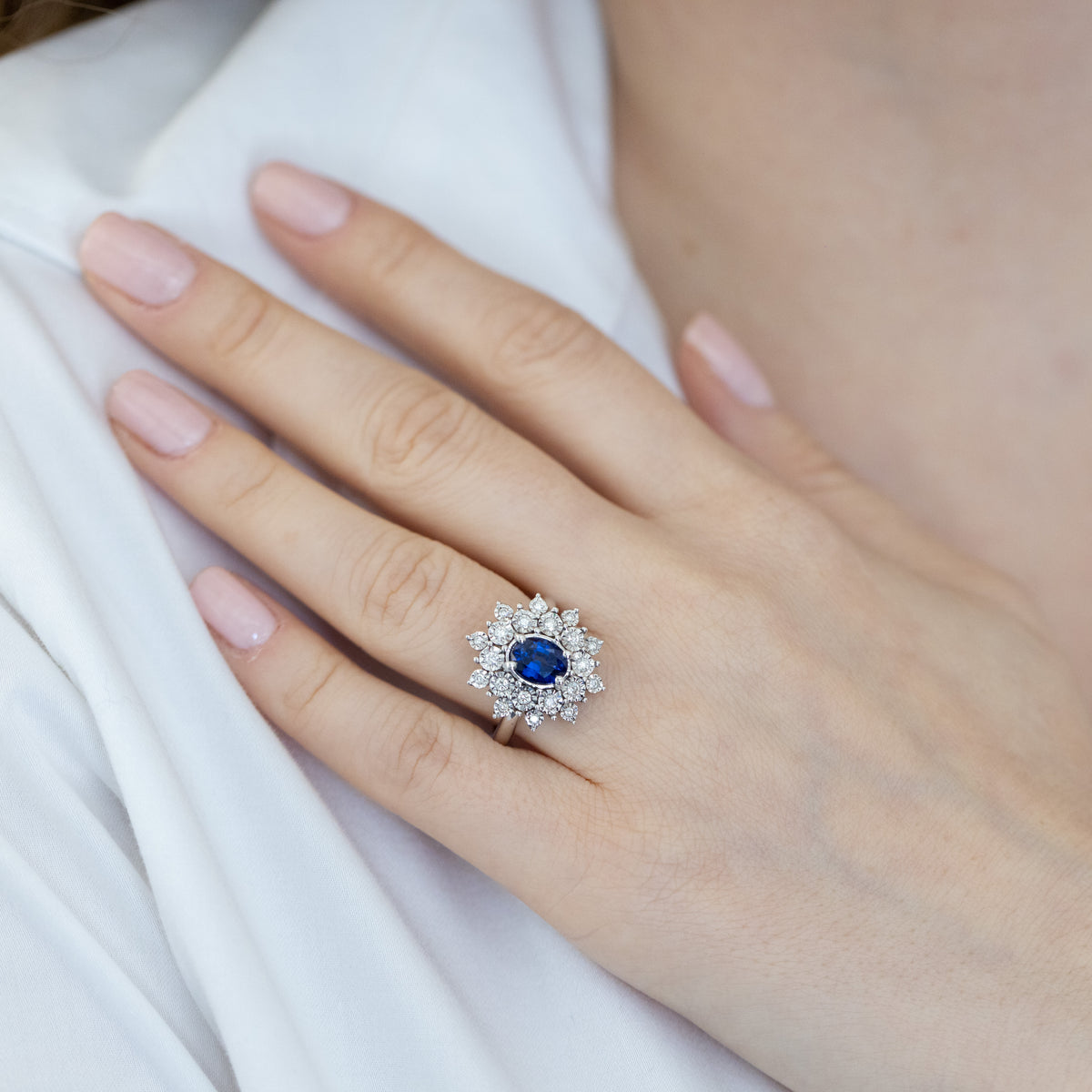 18kt white gold ring with central oval sapphire and double row of diamonds