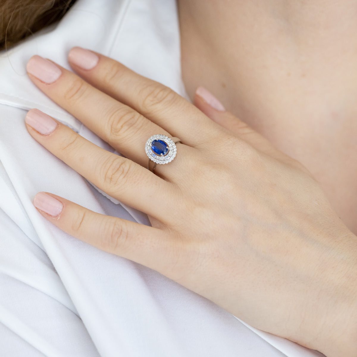 18kt white gold ring with central sapphire and surrounded by illusion diamonds