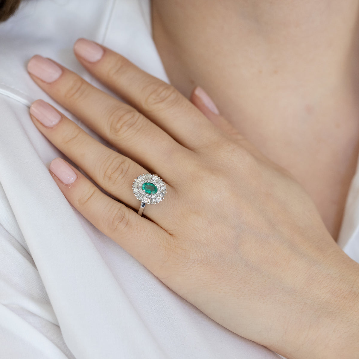 18kt white gold ring with central emerald and illusion diamond surround