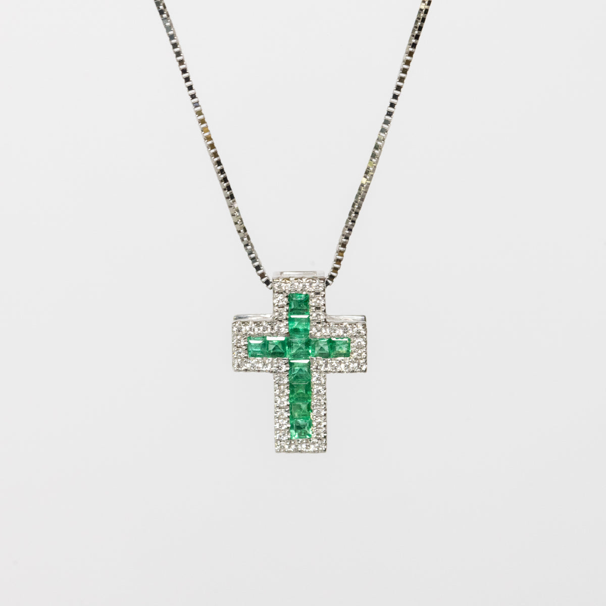 18kt white gold cross necklace with emeralds and diamonds