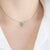 Collana croce in oro bianco 18 kt  con smerladi e diamanti
