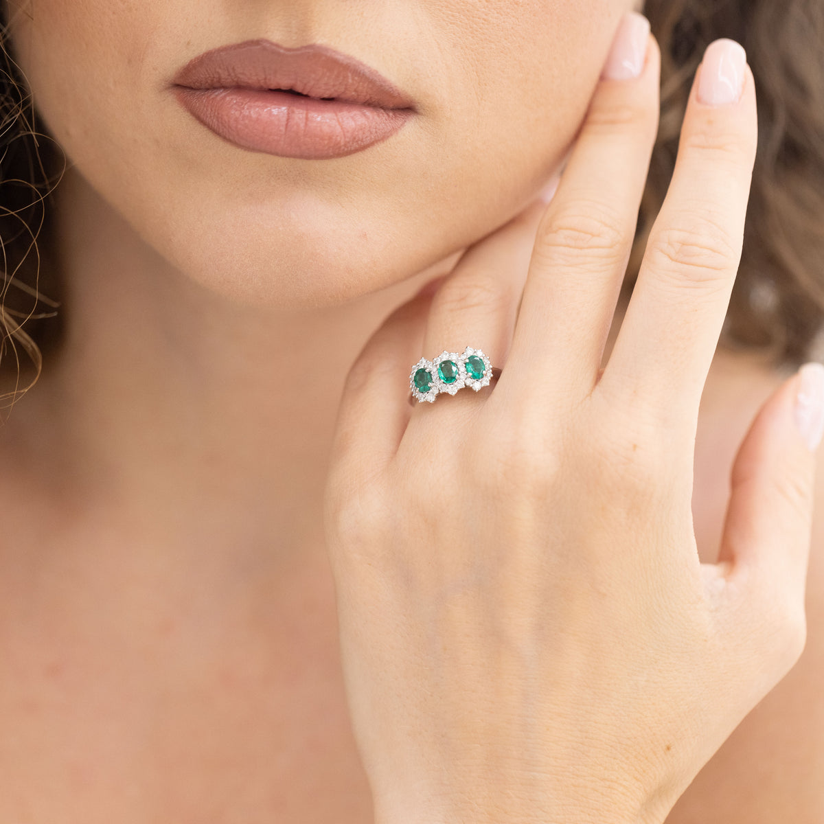 18KT White Gold Trilogy Ring with Emeralds and Diamond Surround