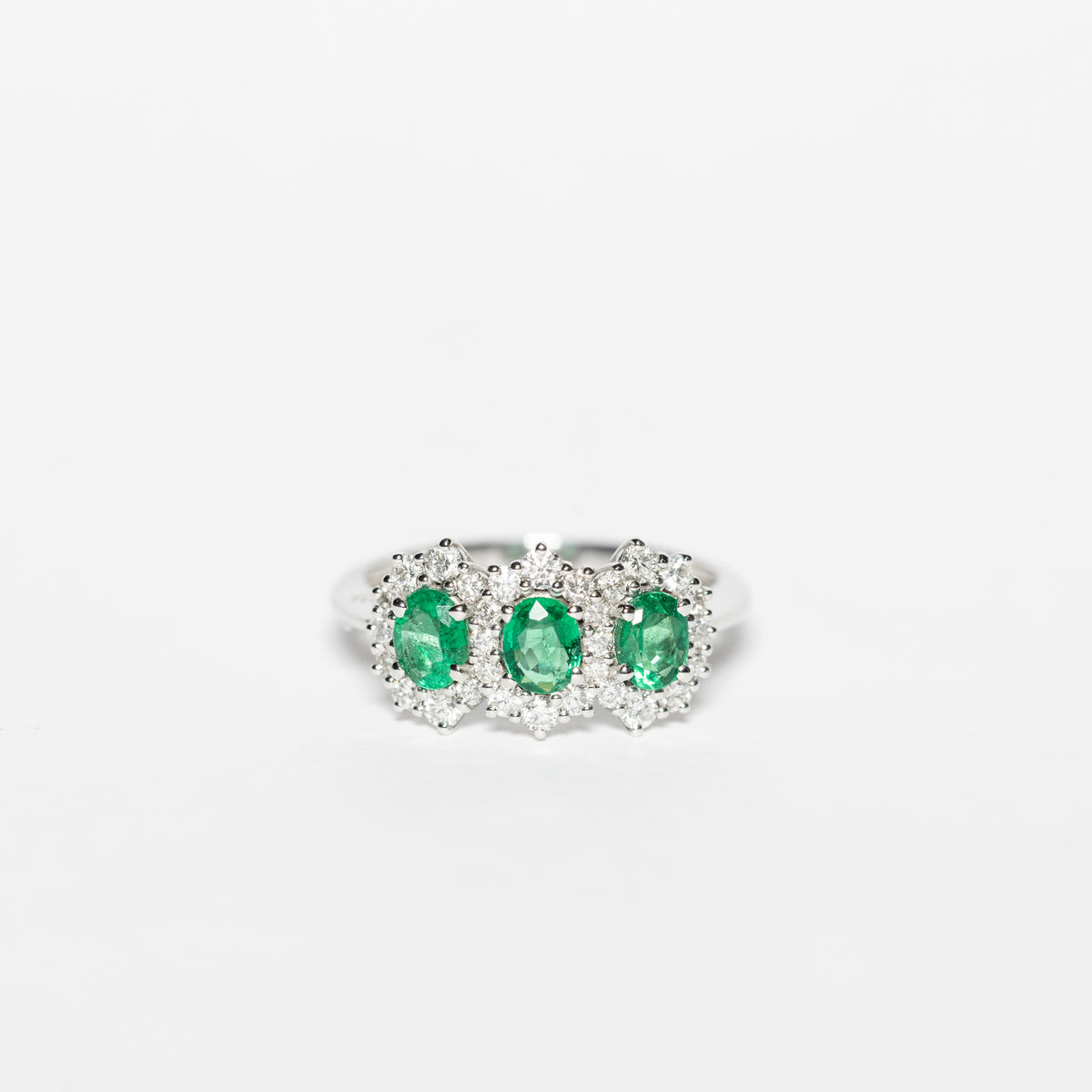 18KT White Gold Trilogy Ring with Emeralds and Diamond Surround