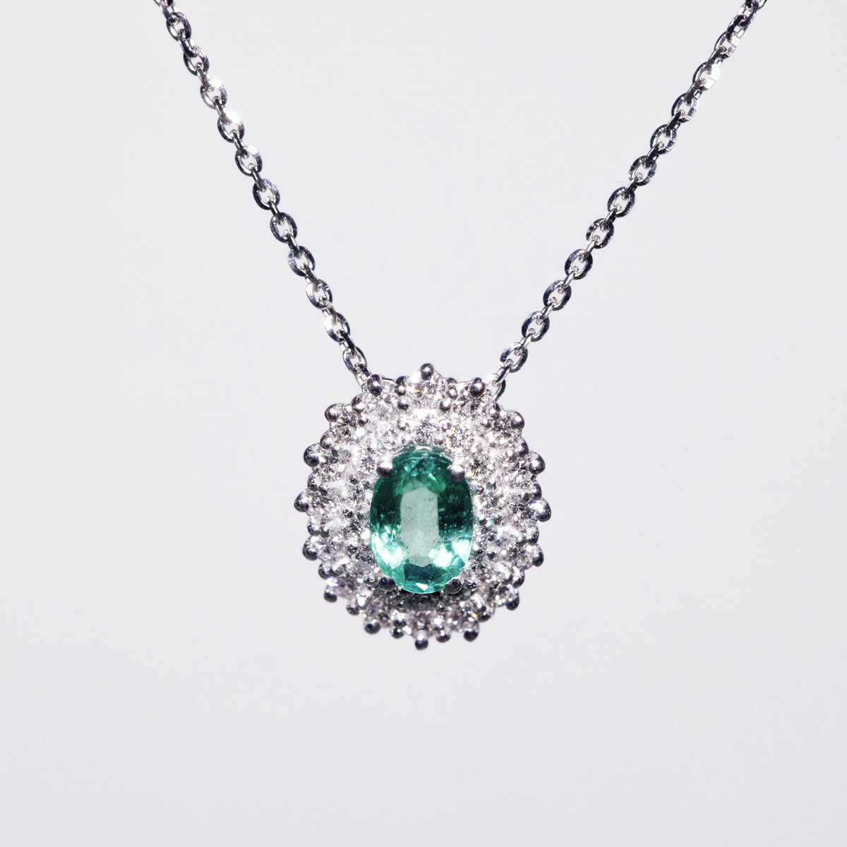 Collana in Oro Bianco 18KT con Smeraldo e contorno in Diamanti