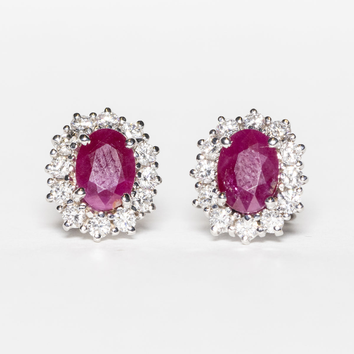 18KT White Gold Earrings with Oval Cut Rubies and Diamond Surround