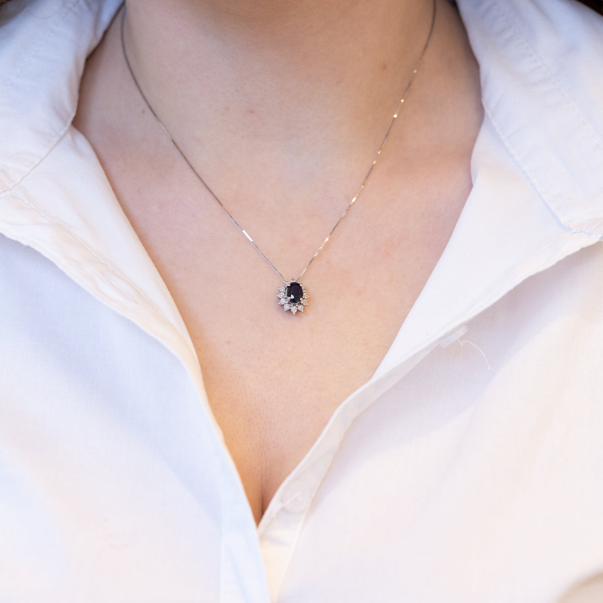 18kt white gold necklace with central sapphire and diamond surround