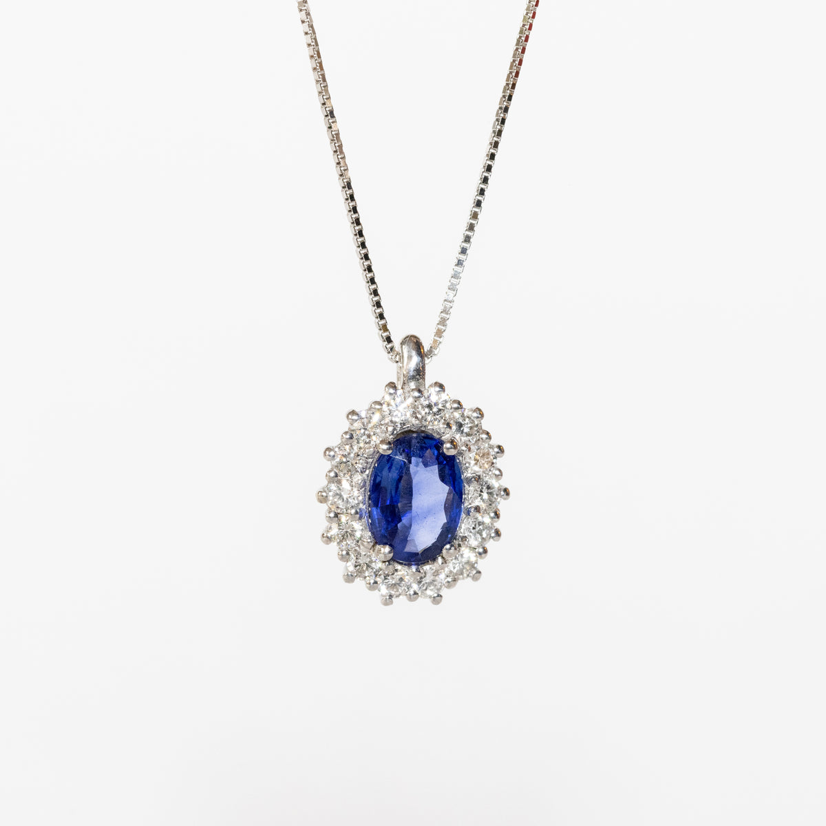18kt white gold necklace with central sapphire and diamond surround