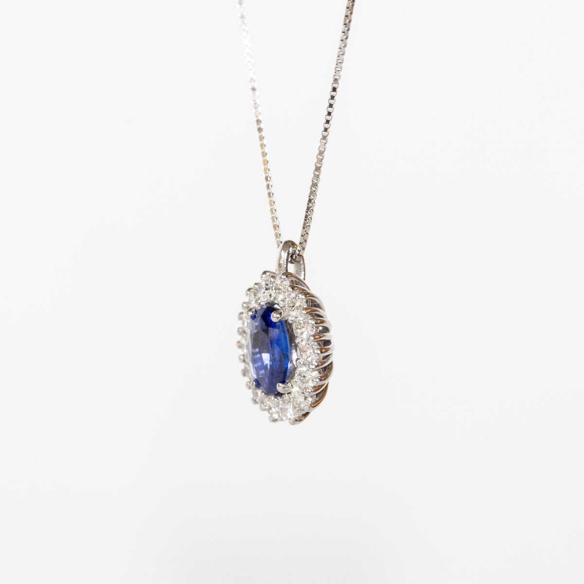 18kt white gold necklace with central sapphire and diamond surround