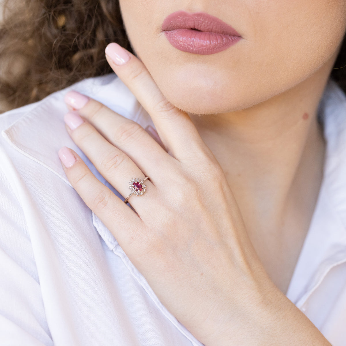 Anello in oro bianco 18 kt con rubino ovale e giro di diamanti