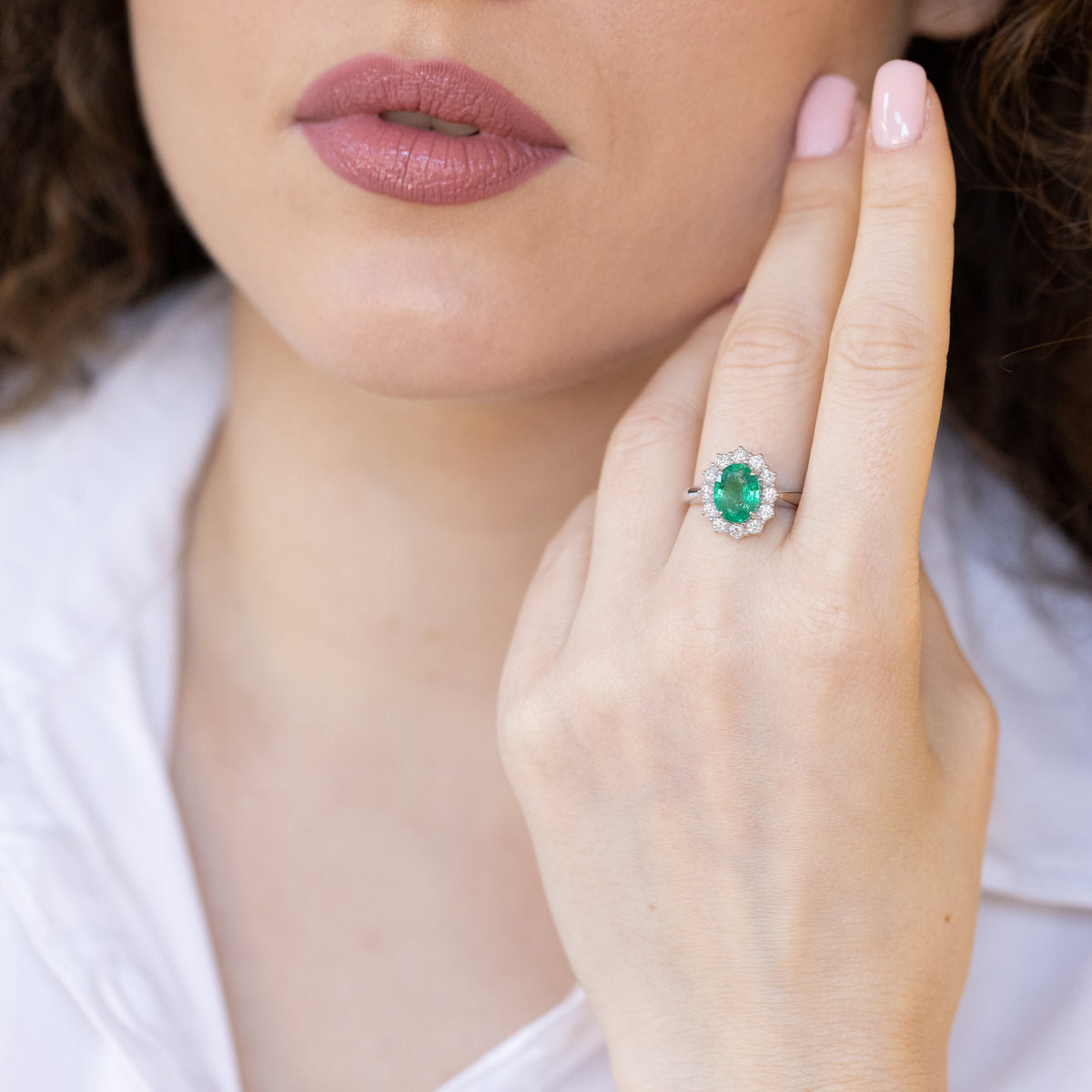 Anello in oro bianco 18 kt con smeraldo ovale e giro di diamanti