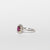 Anello in oro bianco 18 kt con rubino ovale e giro di diamanti