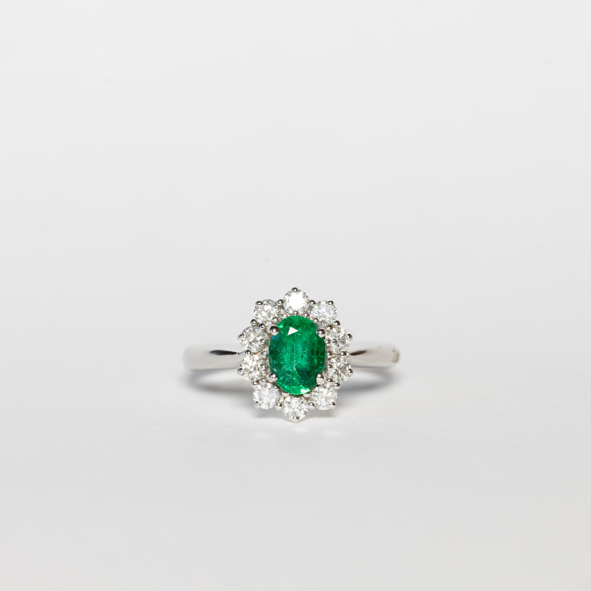 Anello in oro bianco 18 kt con smeraldo centrale e giro di diamanti