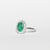 Anello in oro bianco 18 kt con smeraldo ovale e giro di diamanti