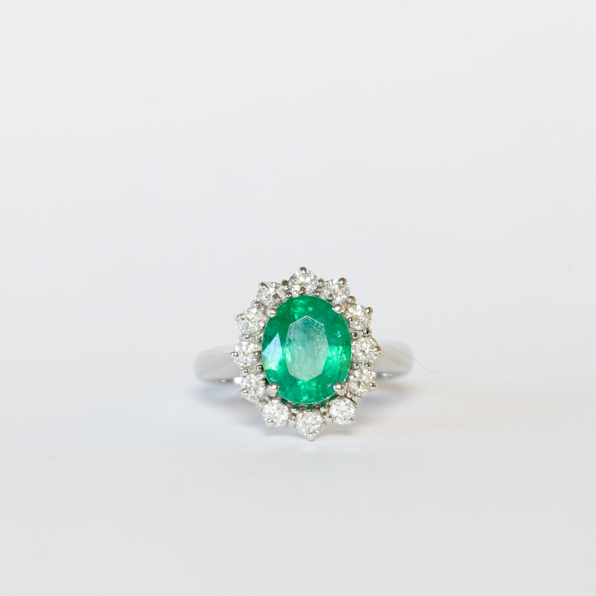 Anello in Oro Bianco 18kt con Smeraldo Centrale e contornato in Diamanti