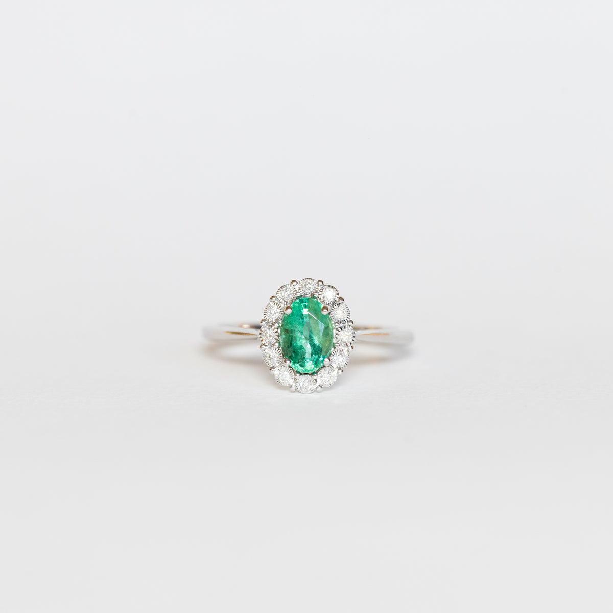 Anello in oro bianco 18 kt con smeraldo centrale con giro di diamanti