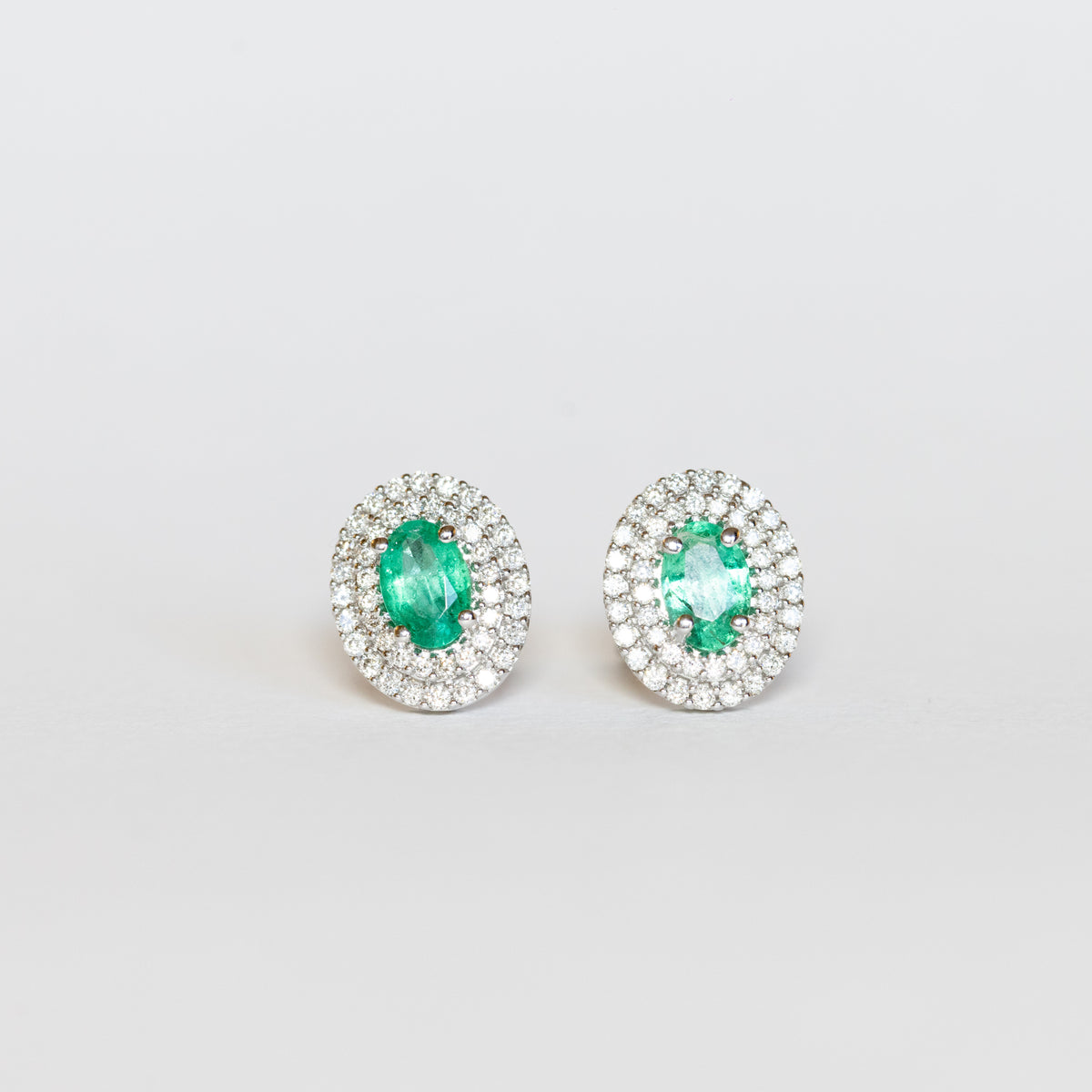 Orecchini in oro bianco 18 kt con smeraldi e doppio giro di diamanti