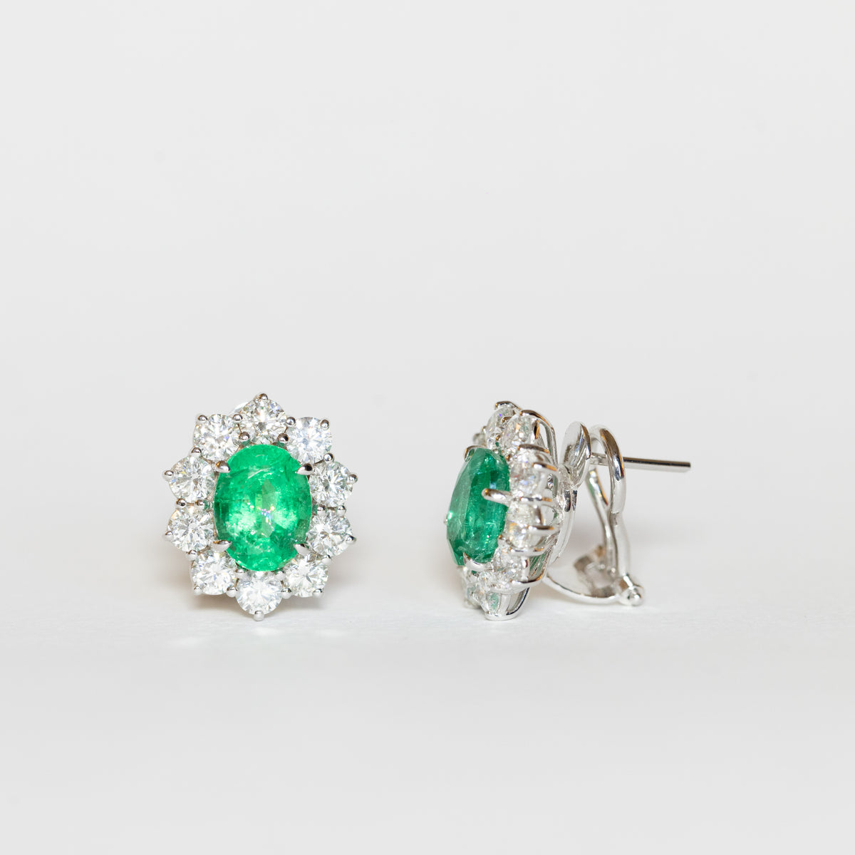 Orecchini in oro bianco 18 kt con smeraldi ovali e giro di diamanti