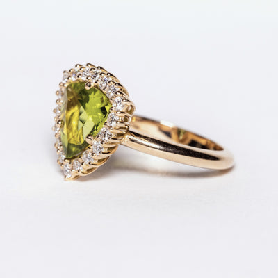 Anello in oro giallo 18 kt con Peridoto contornato di diamanti