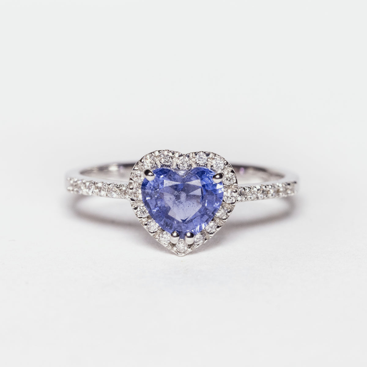 18kt white gold ring with heart-shaped sapphire surrounded by diamonds