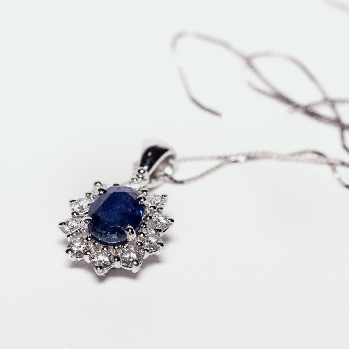 18kt white gold necklace and pendant with sapphire surrounded by diamonds