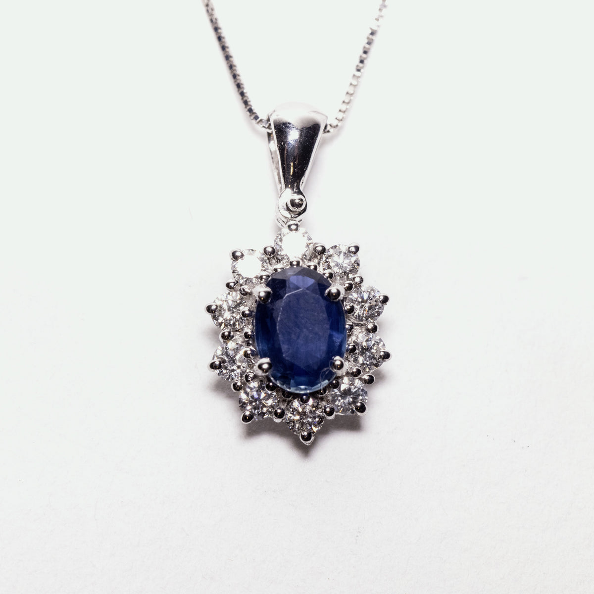 18kt white gold necklace and pendant with sapphire surrounded by diamonds